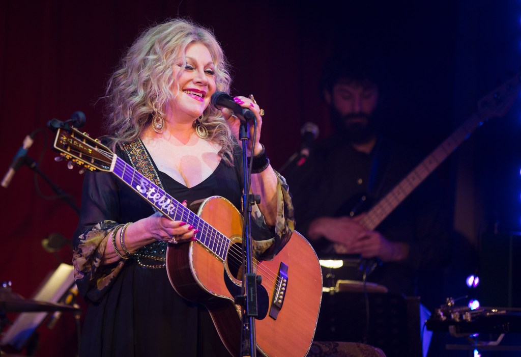 Stella Parton on stage with a guitar