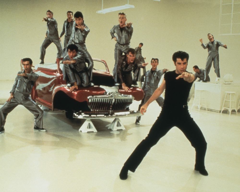 John Travolta leads the cast of 'Grease' during the musical number, 'Greased Lightnin''