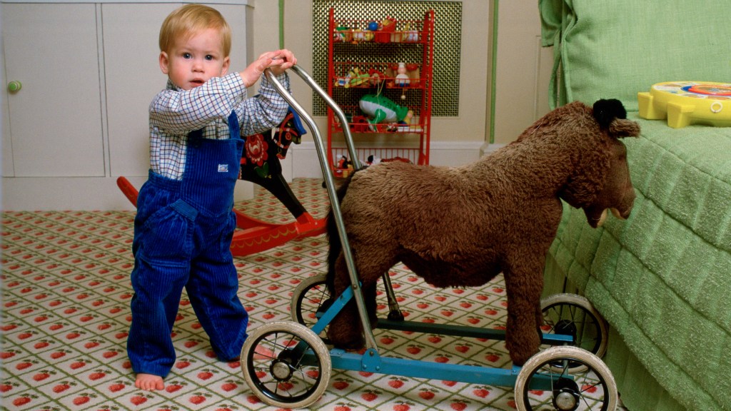 Prince Harry as a toddler with a toy horse
