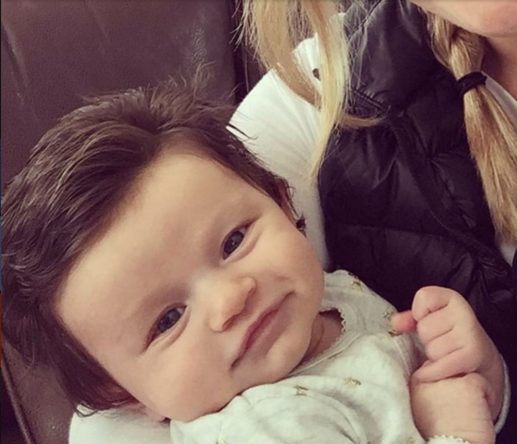 babies born with tons of hair grinning