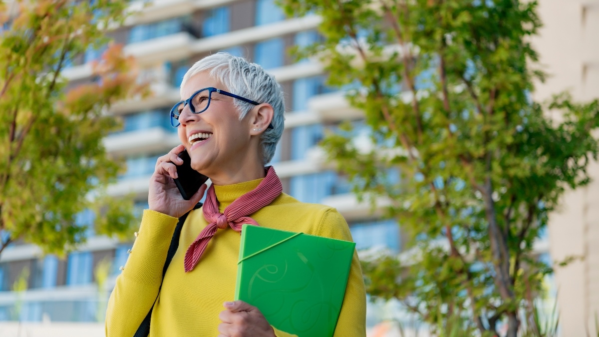 woman in retirement joyfully talks on the phone as she finds a part-time job