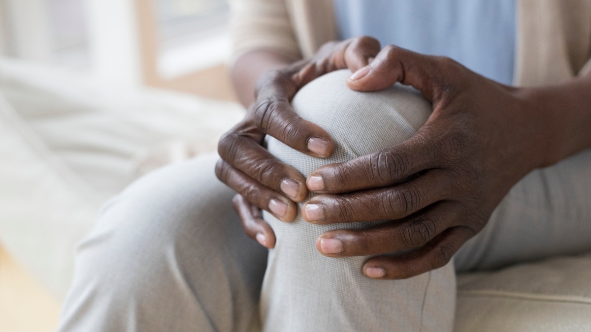 Close-up of a woman holding her knee in pain