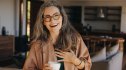 A woman smiling and drinking a cup of tea, which helps prevent a stroke