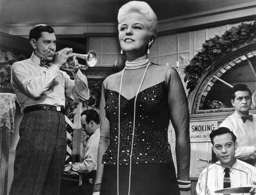 Jazz singer Peggy Lee on stage with a live band