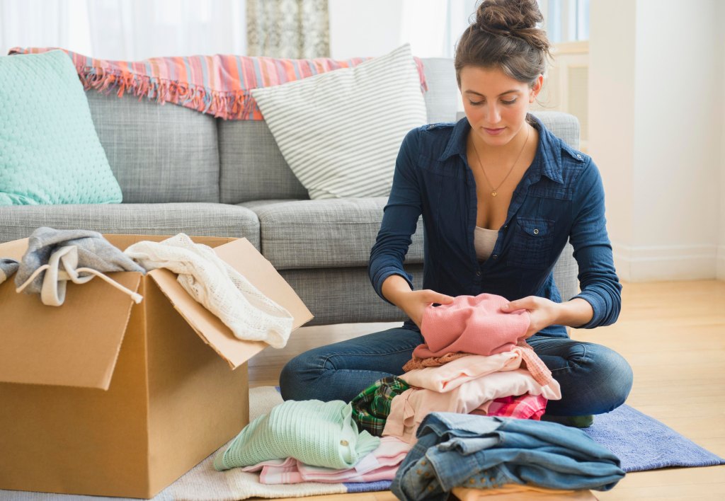 woman packing clothes in a box