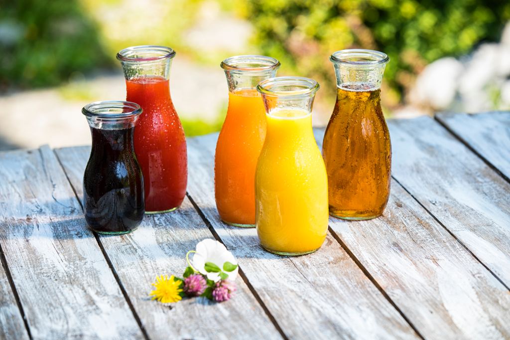 different fruit juices in glass jars