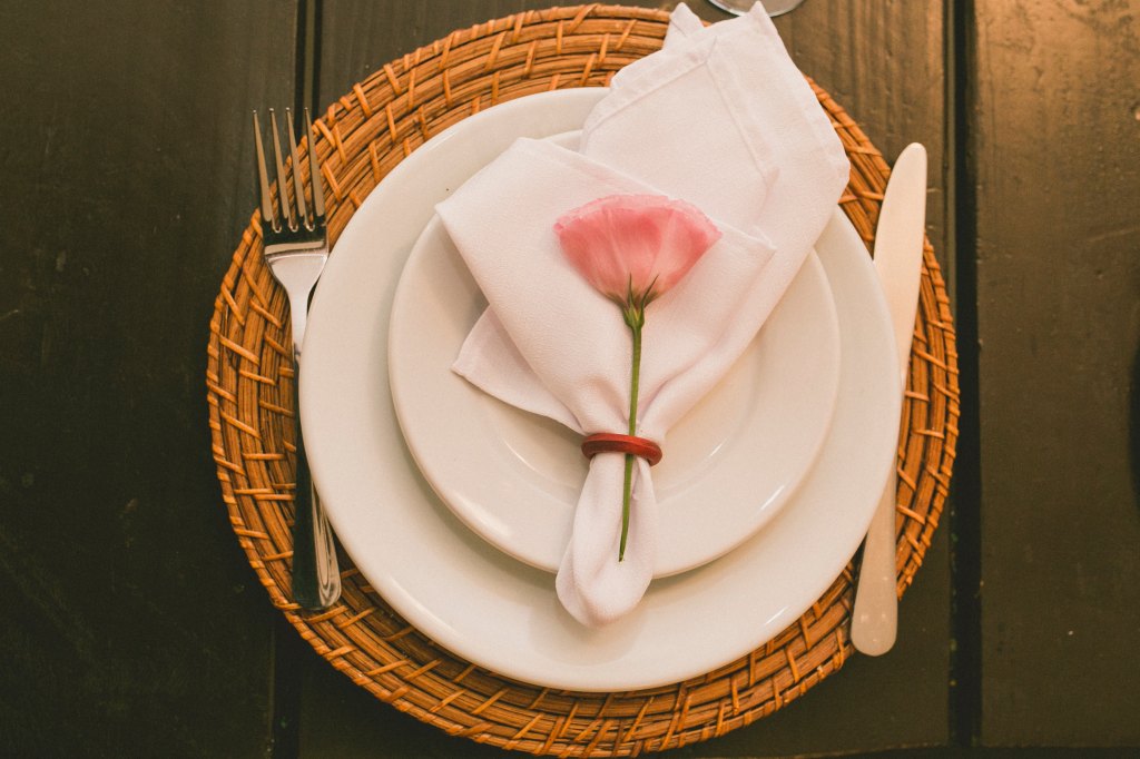 elegant place setting with cone napkin and rose