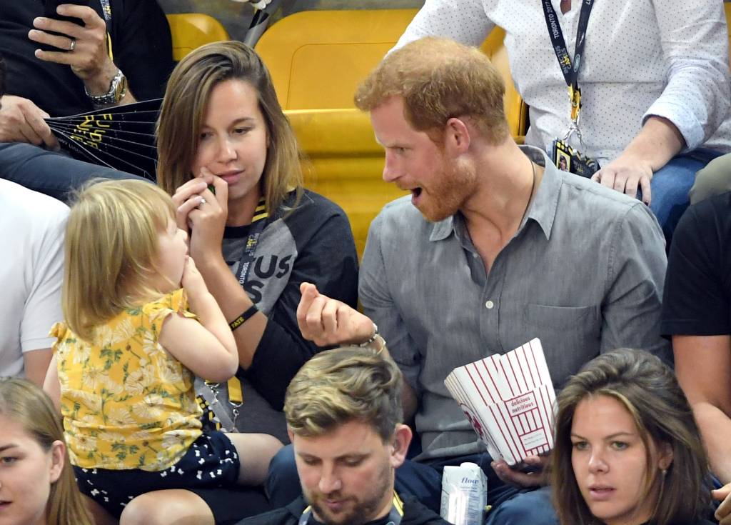 Prince Harry sharing popcorn with little girl