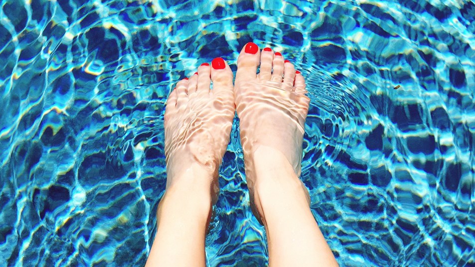 woman's pedicured feet in swimming pool
