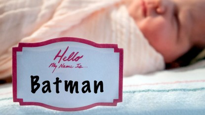 Newborn in hospital bed with name tag reading "Hello, my name is... Batman"
