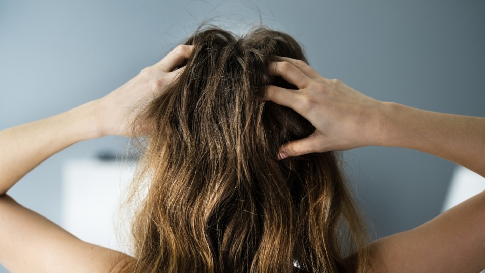 woman giving herself a scalp massage, hands in hair