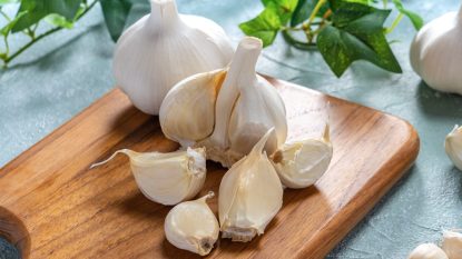 garlic cloves on a wooden cutting board