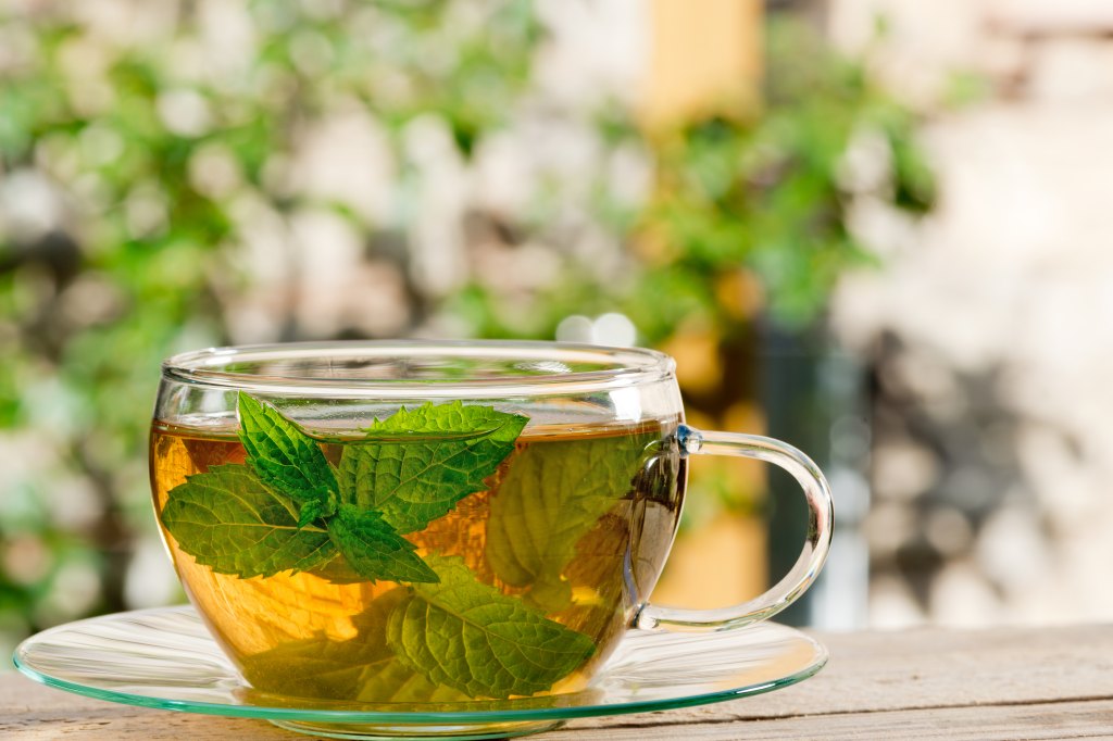 woman smiling sipping peppermint tea