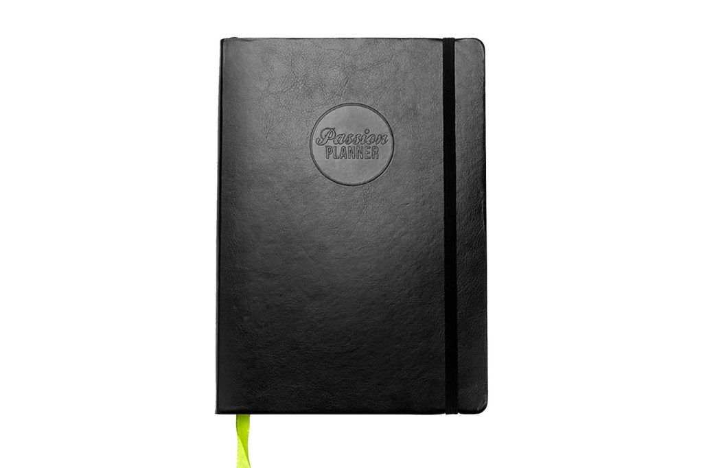black planner with lime green bookmark hanging out the bottom