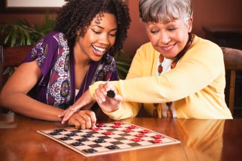 African American woman and her mother playing checkers