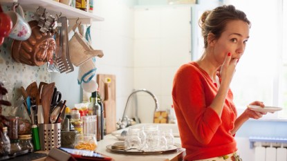 Woman eating in the kitchen