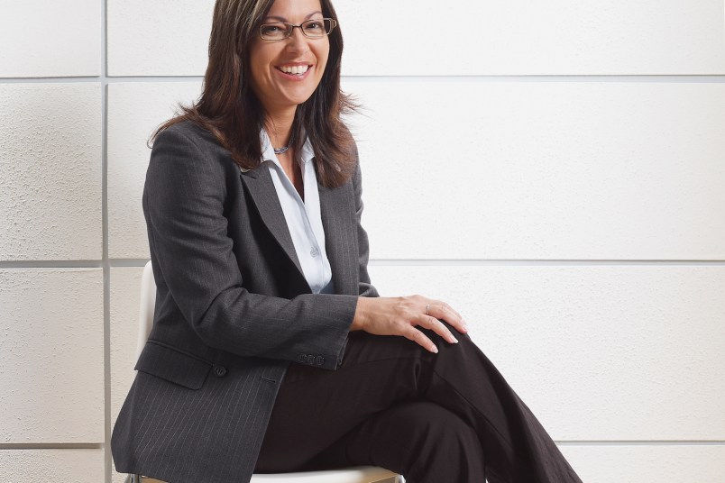 woman sitting in a pair of work pants and a blazer