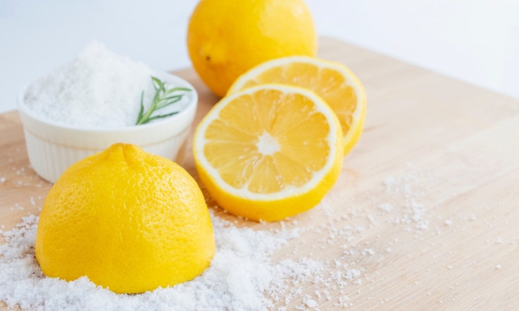Sliced lemons next to coarse salt, which can be used to get rid of germs in your house