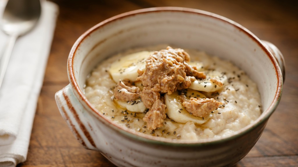oatmeal topped with slice banana, chia seeds, honey and peanut butter.