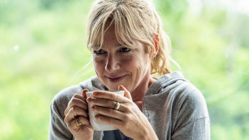 Smiling mature woman having coffee at home