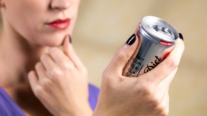 Woman looking at diet soda