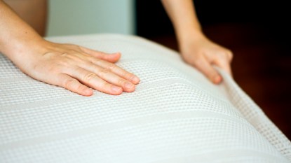 Hands smoothing bed sheets