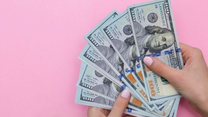 Woman holding $100 bills