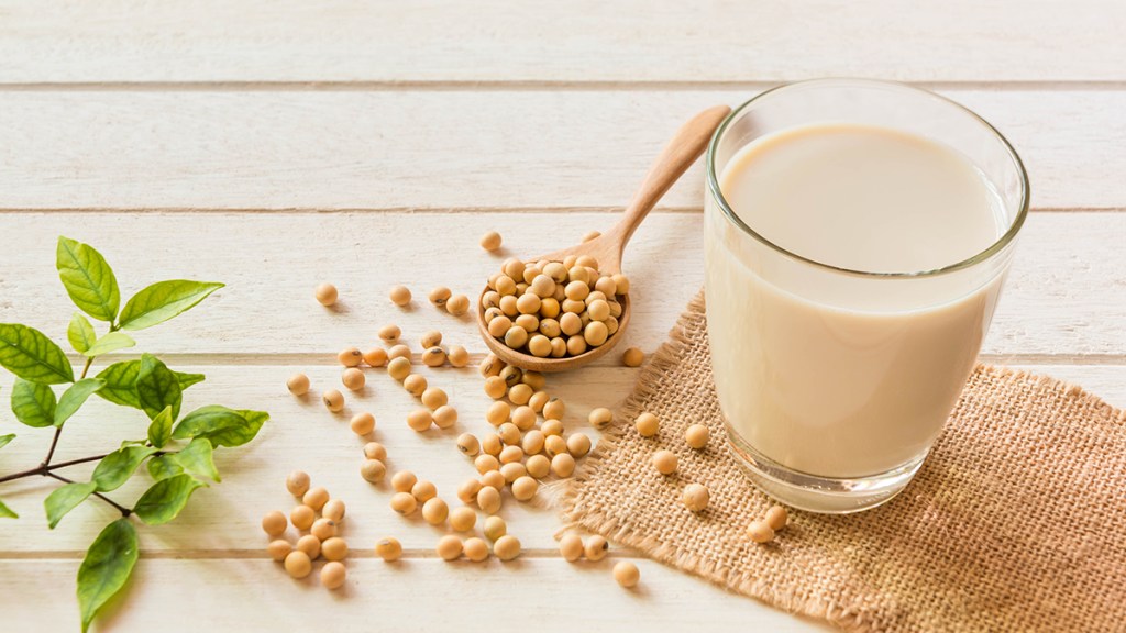 Soy beans next to a glass of soy milk