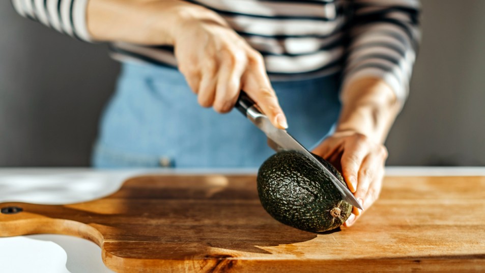 Woman slicing into avocado
