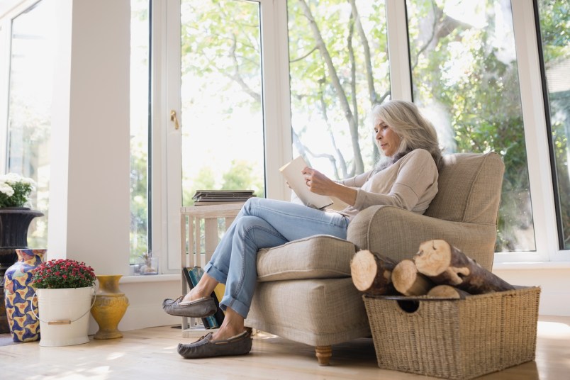 Senior woman reading in armchair