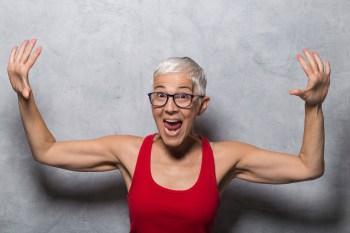 woman with gray hair and toned arms flexing