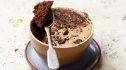 An Oreo mug cake with a spoon dipped into it
