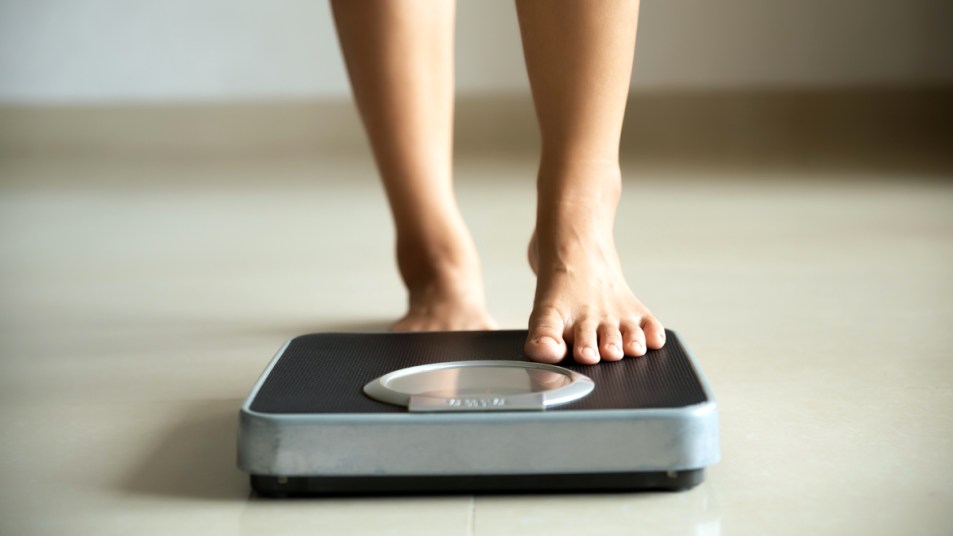 Woman's feet stepping onto a scale