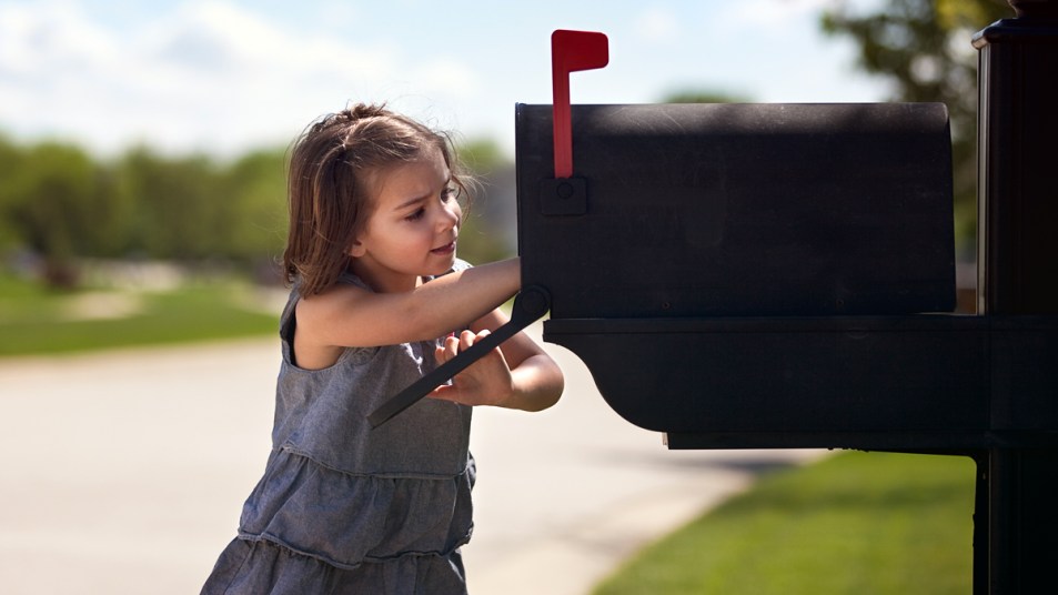 Little girl checking mail box