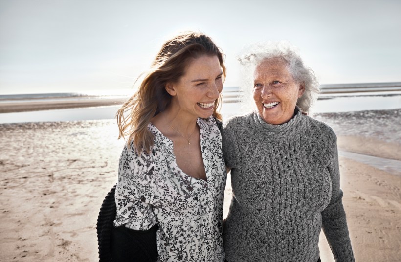 Happy senior woman with her adult daughter on the beach