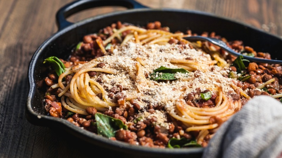 one pot pasta with meat and greens in a skillet