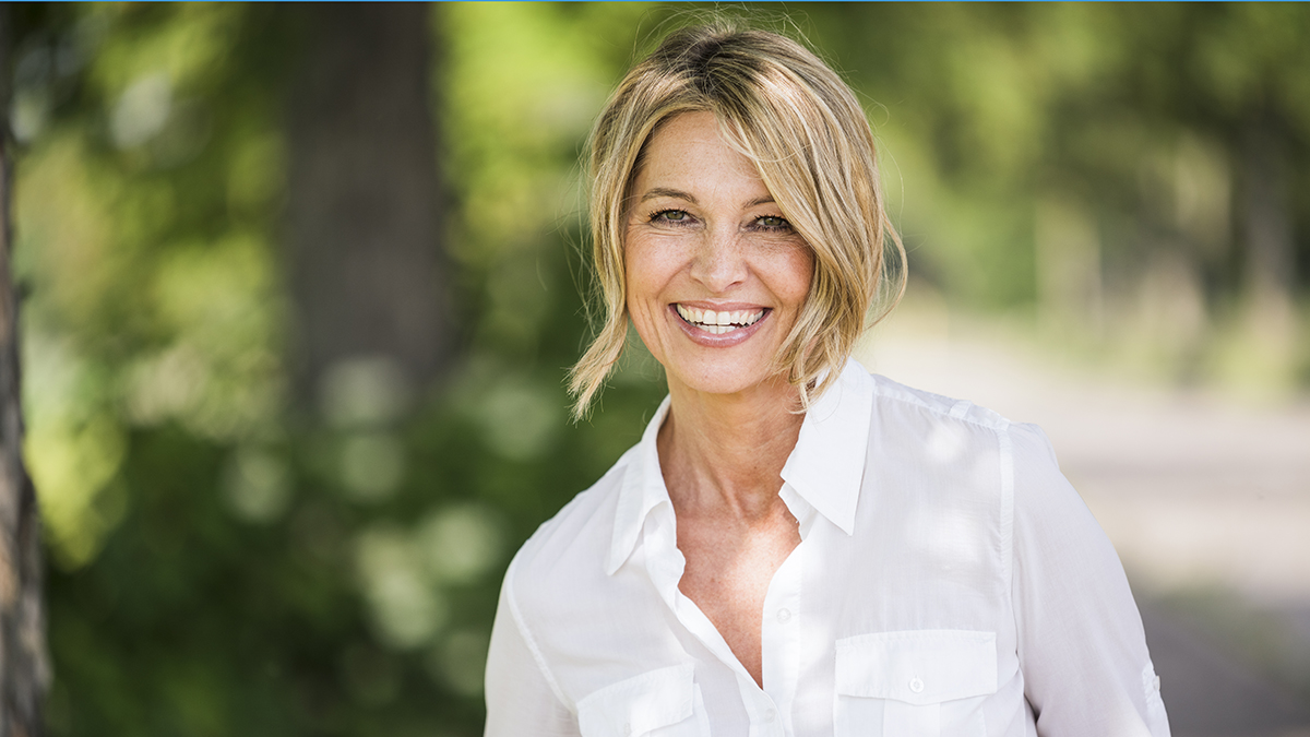 A beautiful, middle-aged woman with full volume hair because of sea salt spray