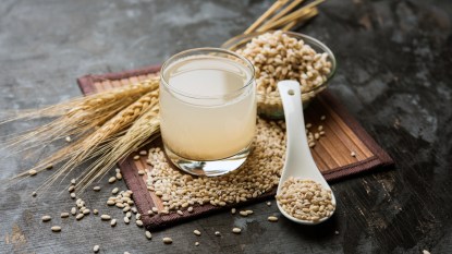 Barley water with raw grains around it