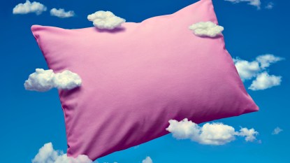 Pink pillow with a blue background and clouds representing dreams