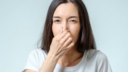 Woman pinching her nose closed