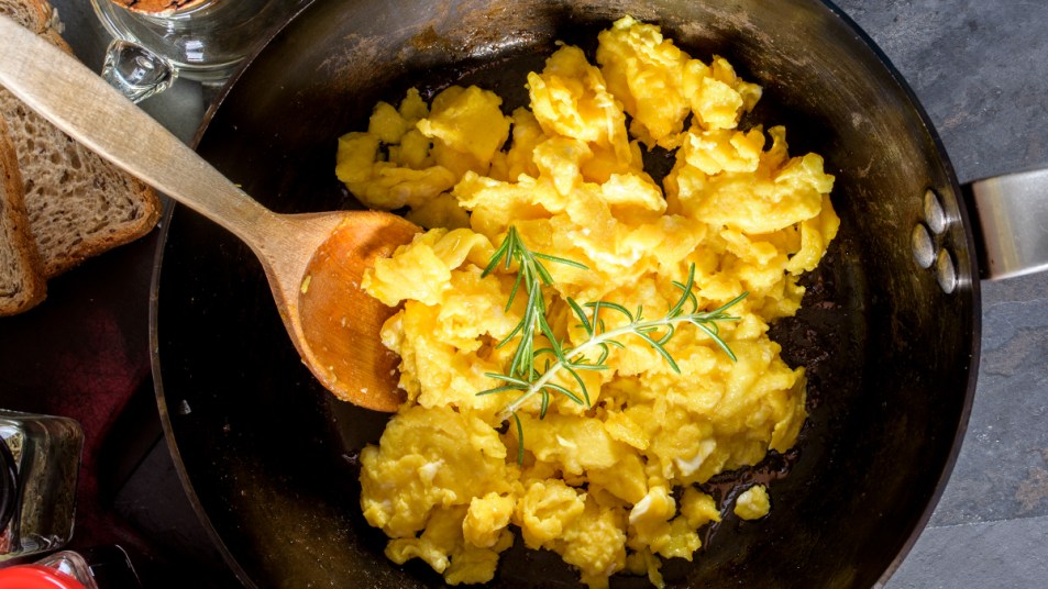 Pan of scrambled eggs with fresh herbs