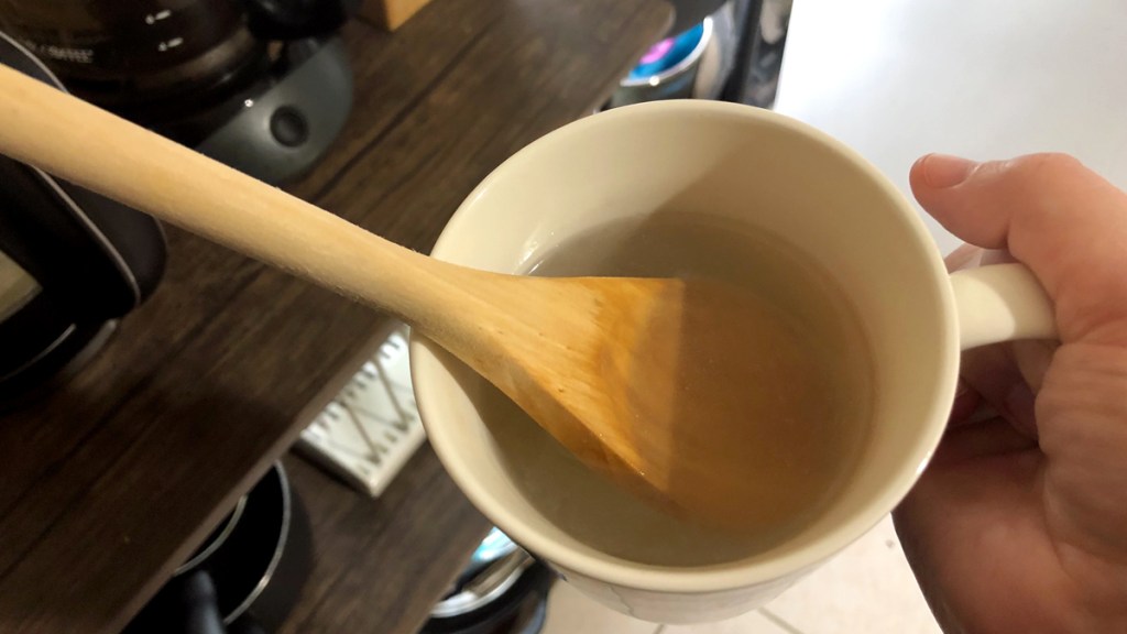 Wooden spoon in a coffee mug of hot water