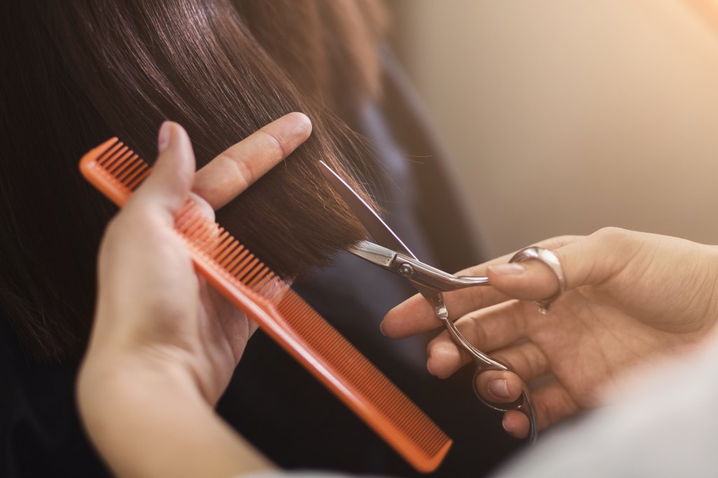 Woman getting her hair trimmed, which is one of the ways for how to prevent split ends