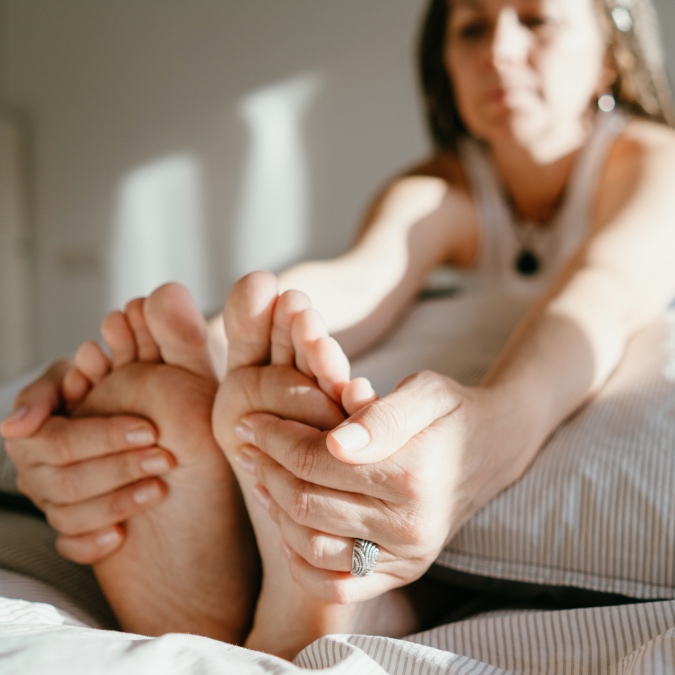 A woman touching her feet to relieve pain