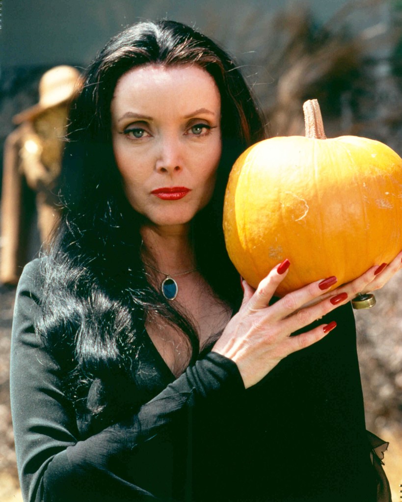 Carolyn Jones [1930-1983), US actress, in costume and holding a pumpkin in a publicity portrait issued for the US television series, 'The Addams Family', USA, circa 1965. The sitcom starred Jones as 'Morticia Frump Addams'