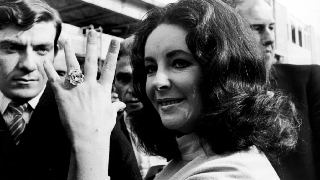 Elizabeth Taylor showing off enormous diamond ring given to her by Richard Burton, 1965