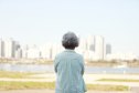 Rear view of senior woman standing by river bank