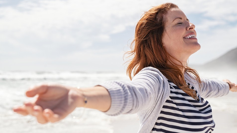 woman on beach strengthening lungs by breathing salty sea air