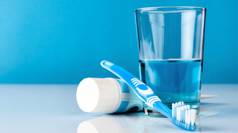 Toothpaste, toothbrush, and glass of mouthwash