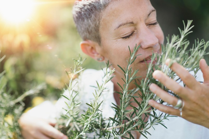 woman smelling rosemary herbs